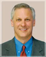 A headshot of a man in a suit.