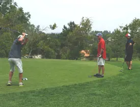 Four men playing golf on a course.