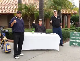 Three men standing at a golf course registration.